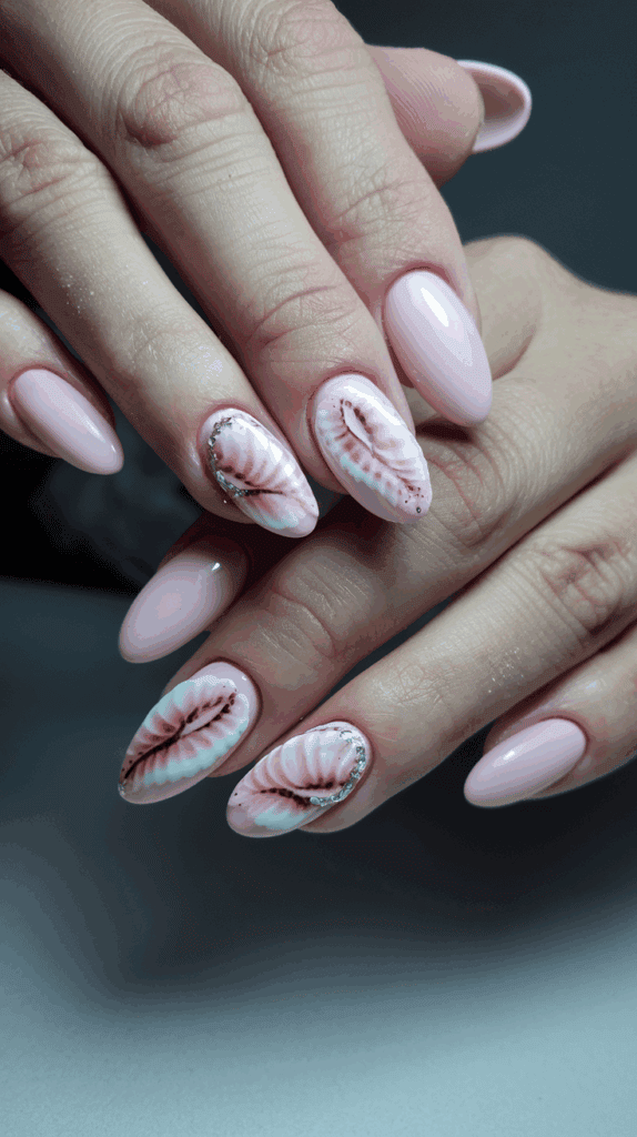 A hand displaying a manicure with pale pink nails featuring intricate pink and dark red leaf designs, accented with small silver glitter details.