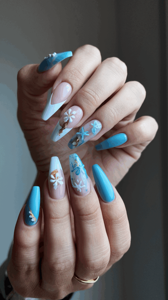 Hands showing long, manicured nails with a coastal theme, featuring blue and white polish, seashells, and starfish designs with 3D embellishments.